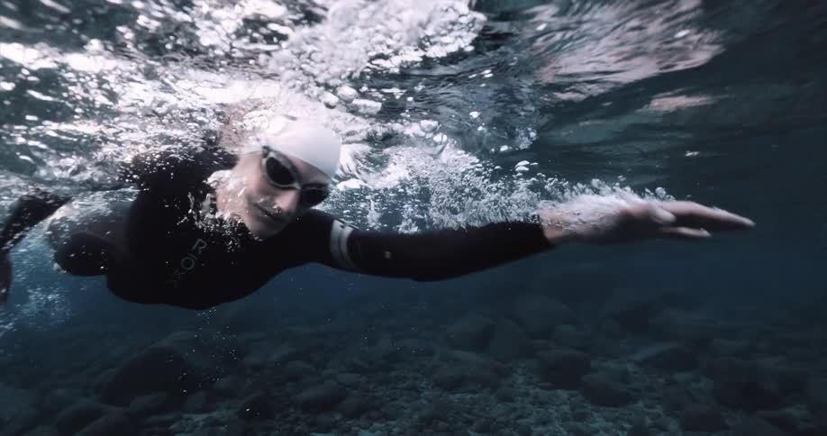 A swimmer swims underwater