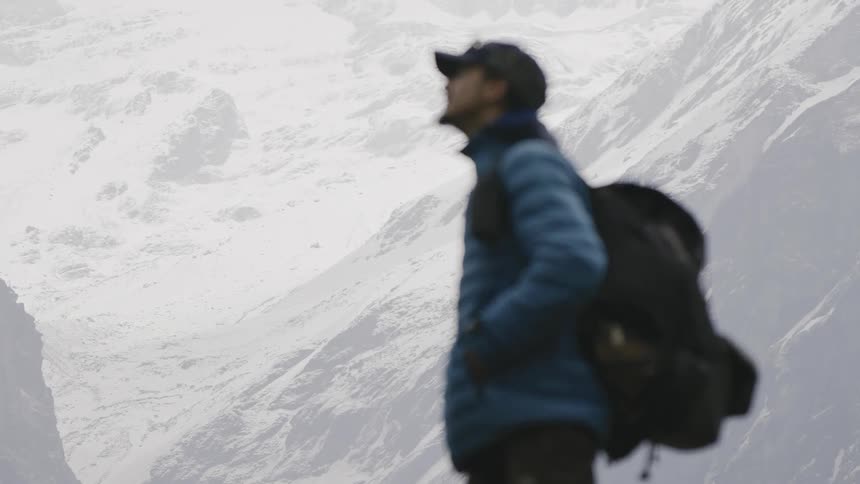 A backpacker on snowy mountains taking in the scenery