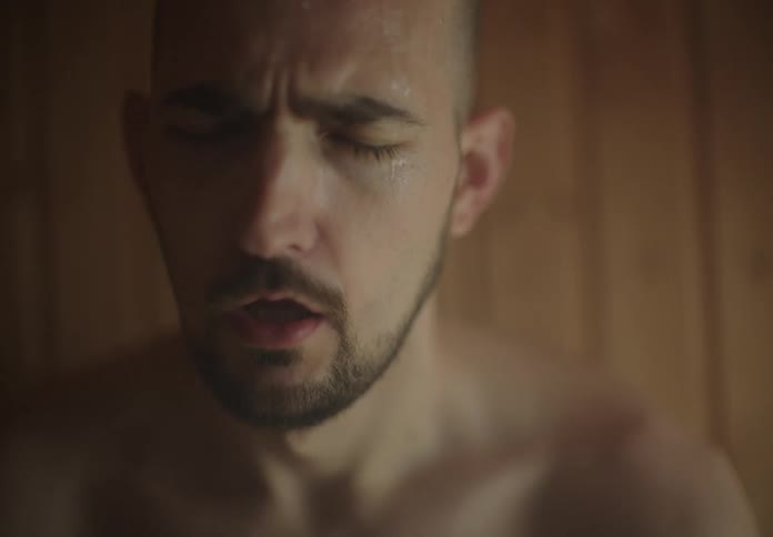 Man taking deep breaths while sitting in a sauna
