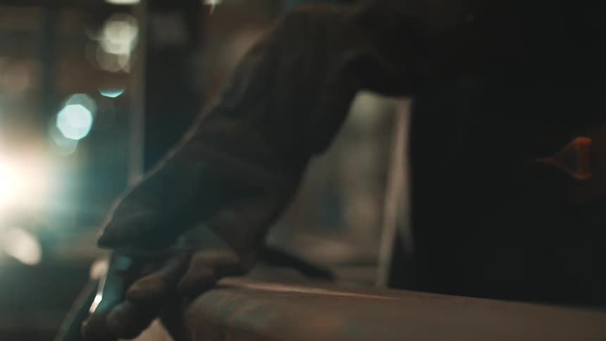 An employee puts on welding gloves in preparation to weld steel