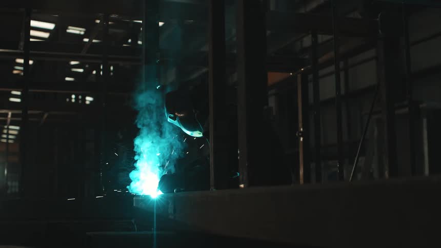 A man is welding in the warehouse