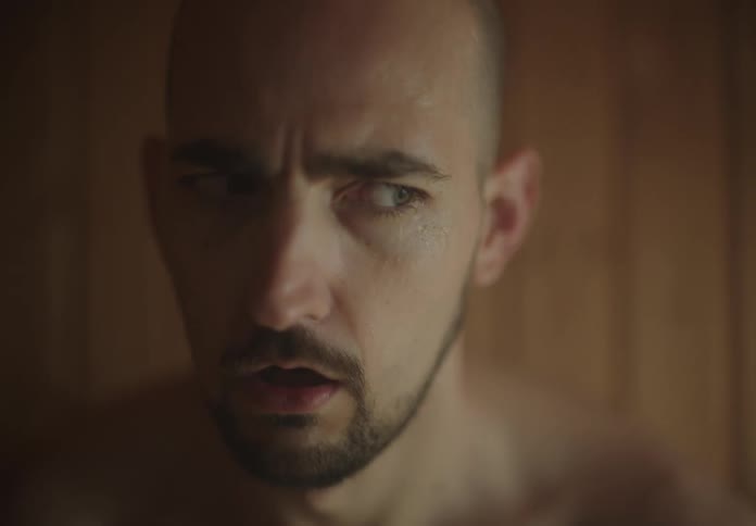 Close up of the face of a nervous man sitting in a sauna