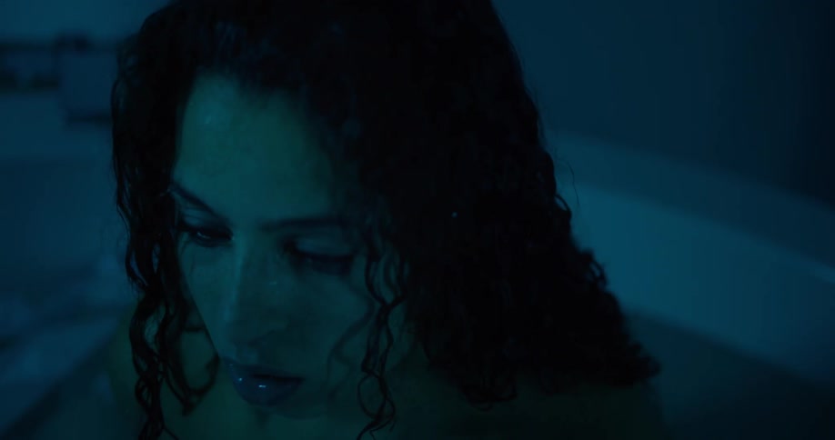 Portrait of a woman with wet hair moving in a bathtub