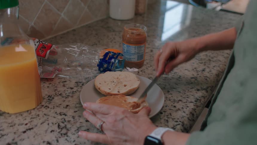 A woman preparing peanut butter jelly sandwich at home