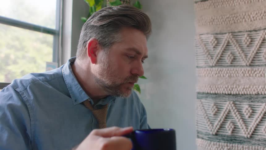 Man sitting eating and drinking a cup