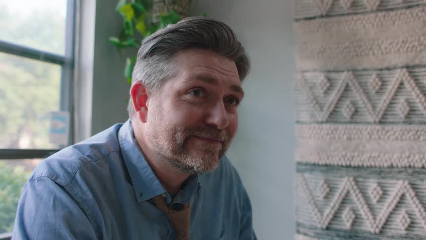 A man drinks coffee and smiles
