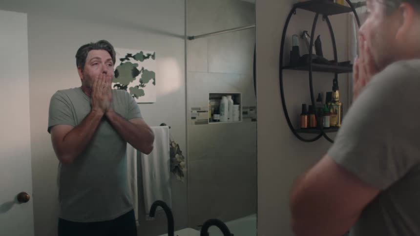 A man washes his face in the sink