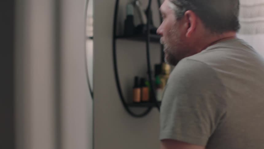 Side portrait of a man waiting in the background and exiting the bathroom