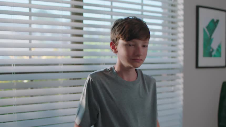 A boy is getting dressed in his room