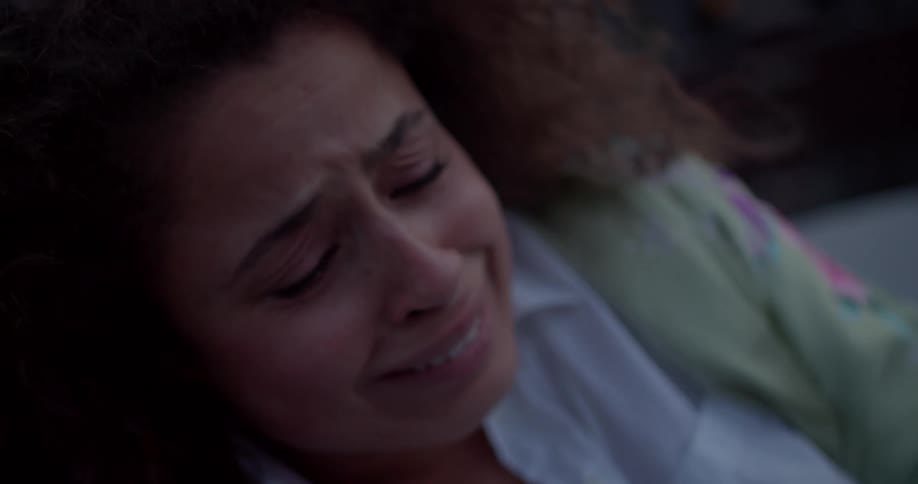 A closeup of a womans face reveals fear as she grimaces in pain