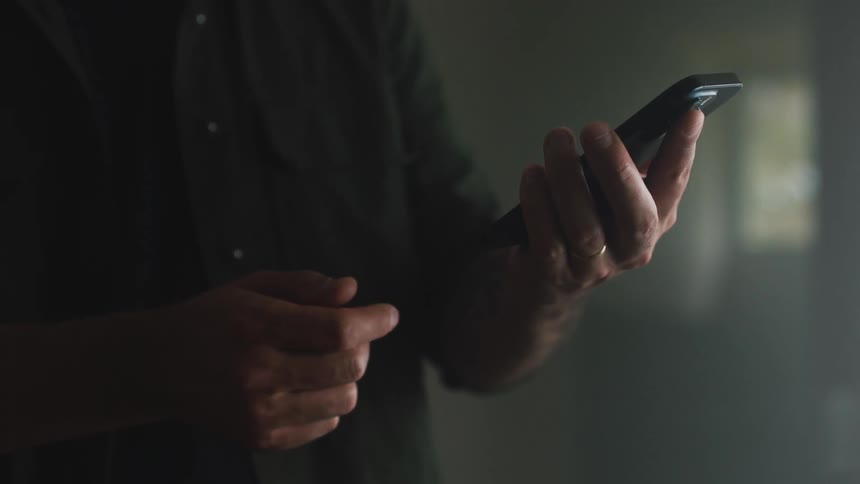 Person holding a cell phone in their hand while making gestures with his other hand