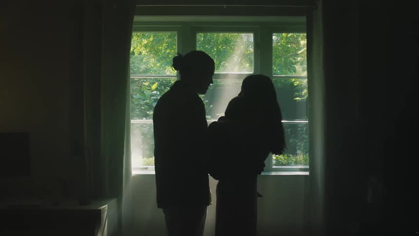 Parents stands with their child near window