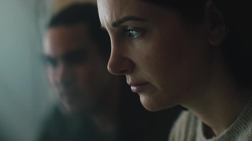 A man and woman are talking while looking at something