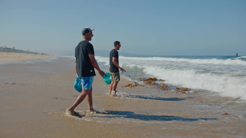 Two men at sea with equipment to remove garbage