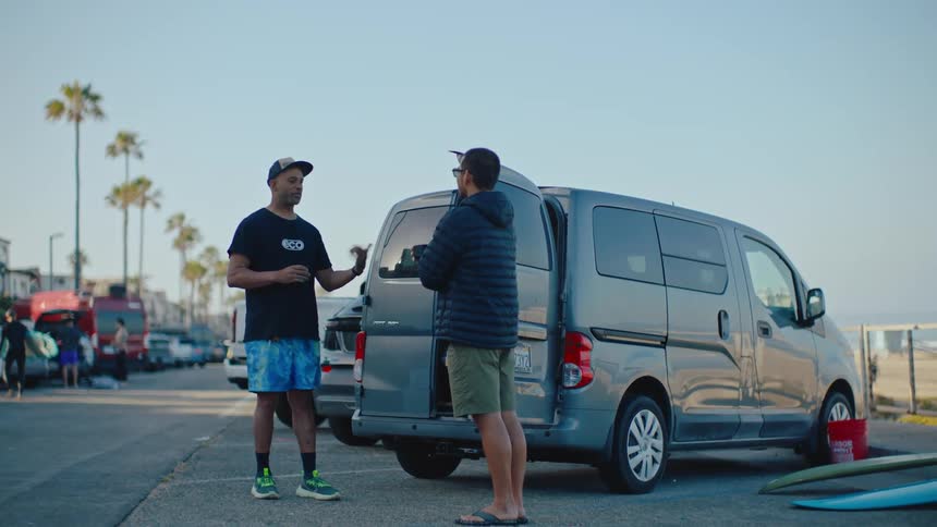 Two men are talking by the van