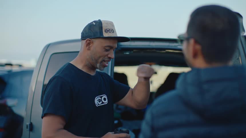 Two men talk near the van