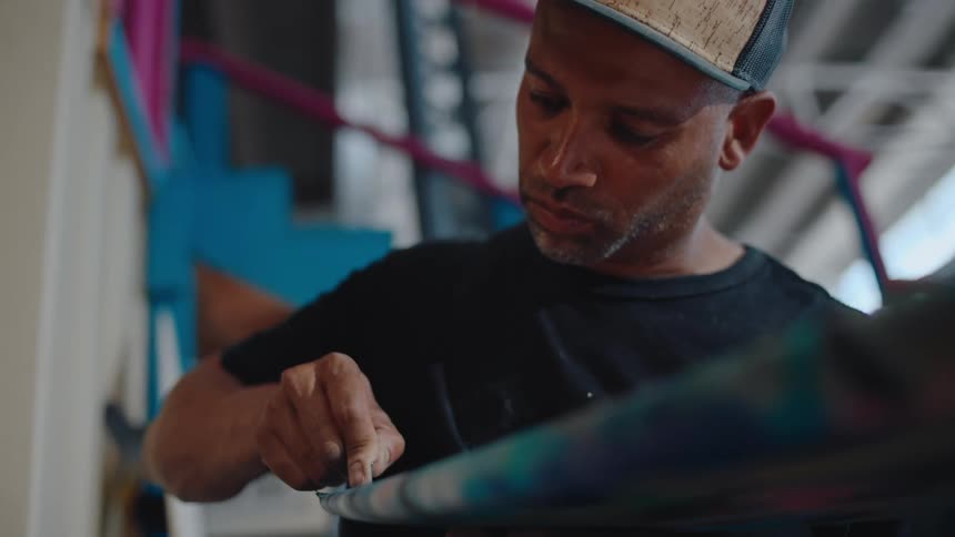 A worker cuts a tube like surface with a razor blade