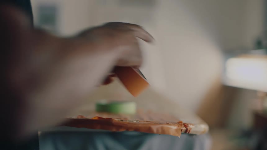 A man is taping up a surfboard