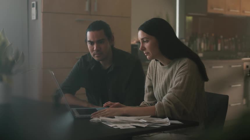 Man and woman sitting at the table at home using a laptop