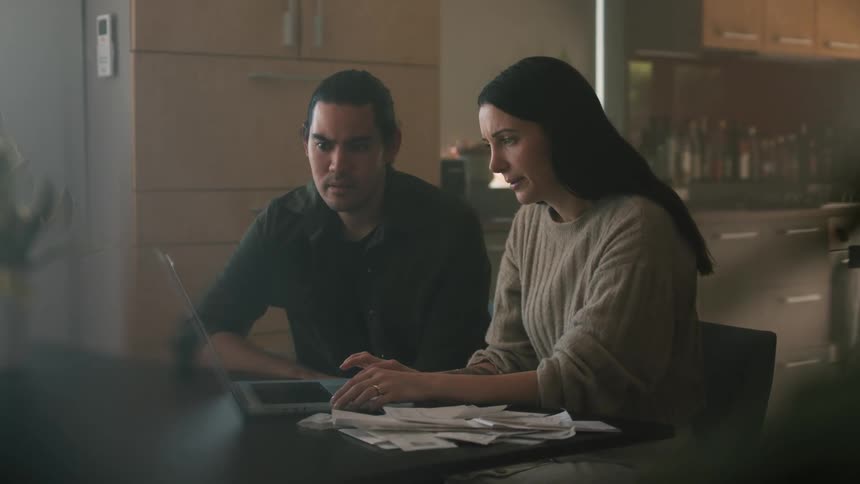 Man and woman become upset while checking their finances on a laptop