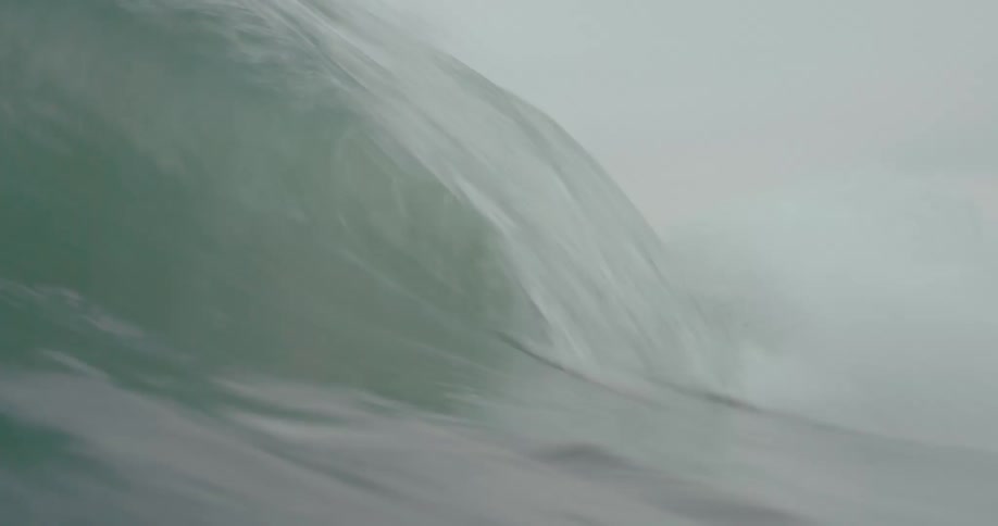 An ocean wave rolls and crests