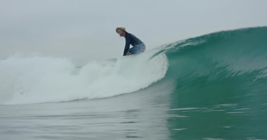 A man is riding a wave on his surfboard