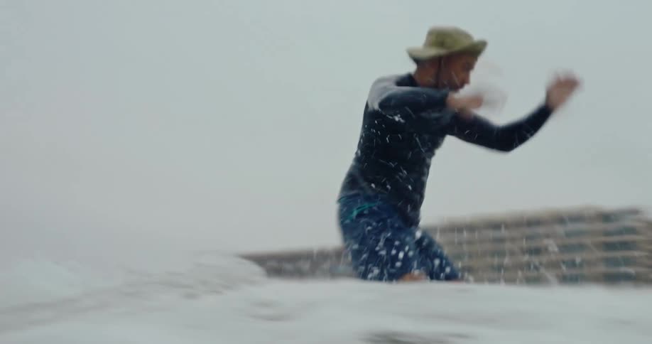 Man surfing a small wave on a cloudy day