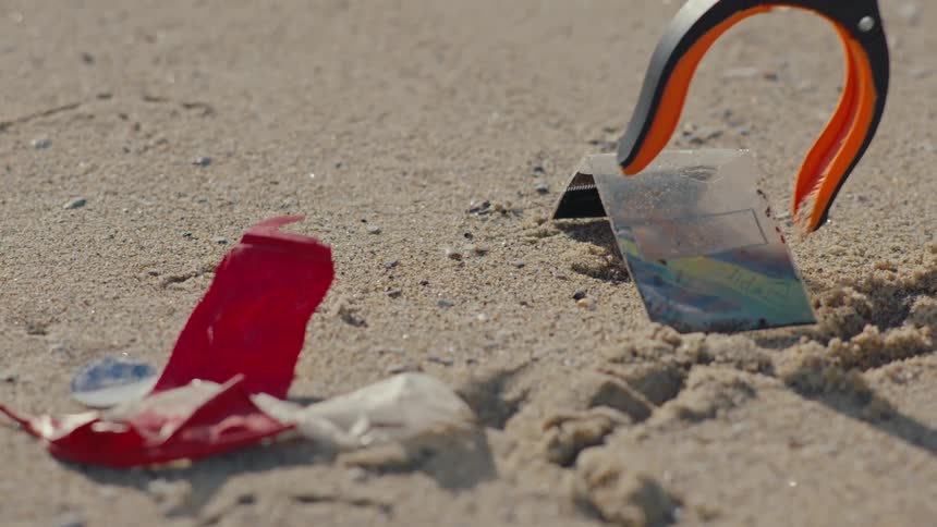 Reacher grabber is used to pick up litter on the beach