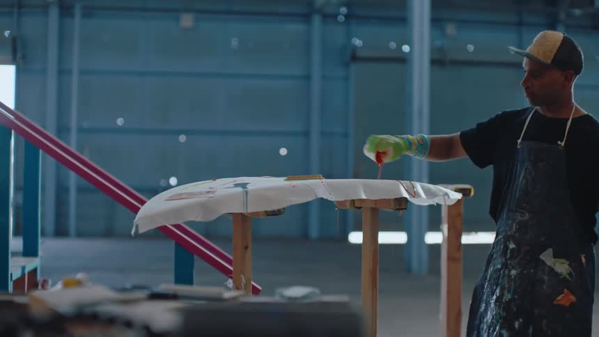 Man pouring paint over a surfboard
