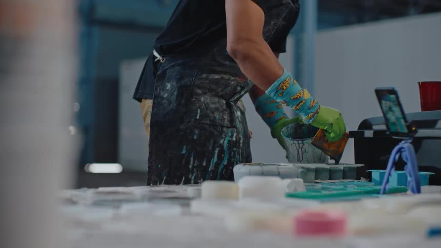 Man at a workbench engaged in an artistic activity with paint