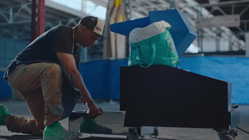 A worker rinses an object off in a pan