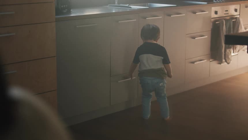 A child walks over and opens a drawer