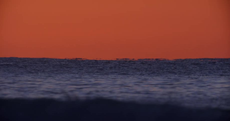 Ocean landscape against a reddish sky