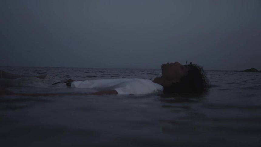 Person in a white tshirt lying down and floating in calm waters