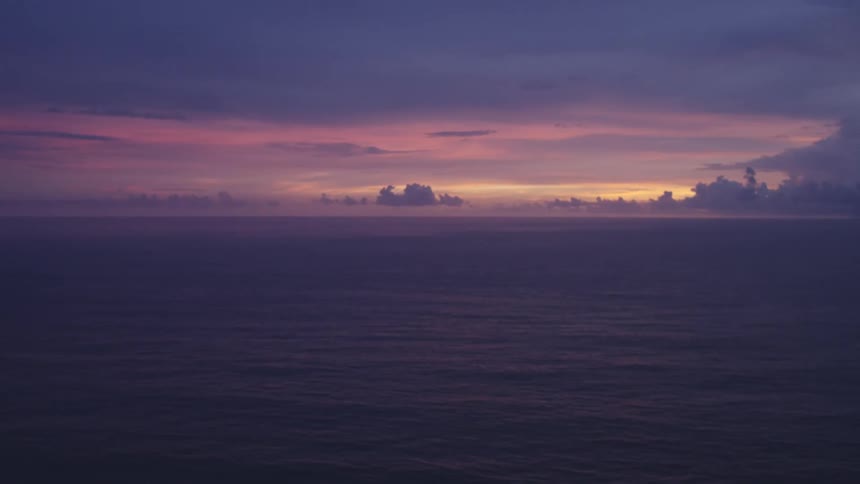 Seascape at dusk with a gradient of colors from purple to orange in the sky