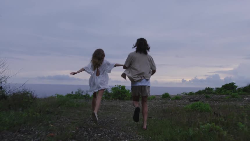 A couple run while holding hands