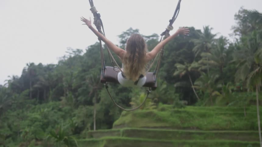 A woman swings in the jungle