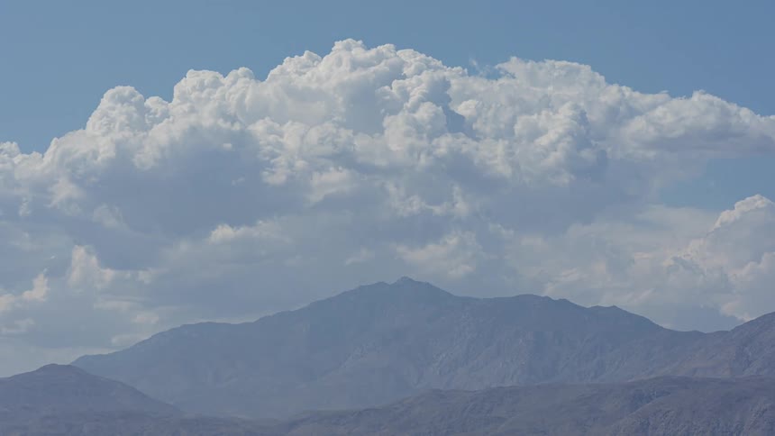 Landscape of mountain ranges with clouds passing above