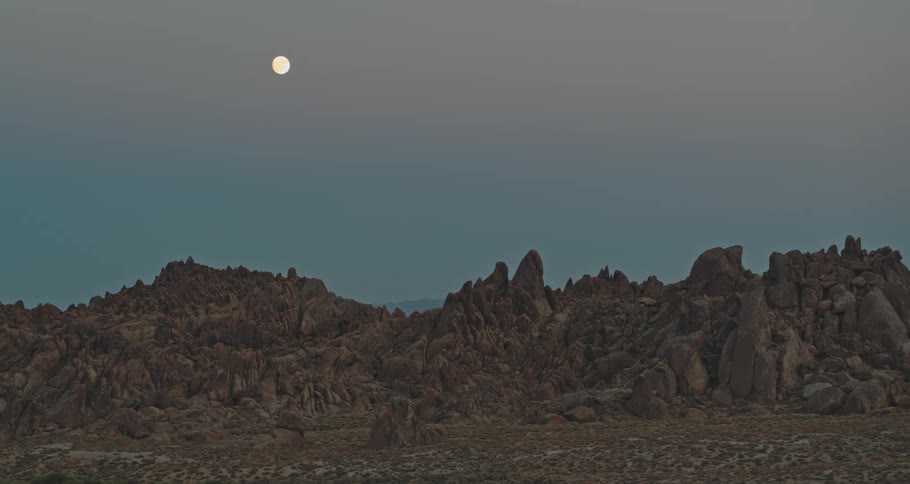 Mountain landscape with rocks and the moon on the horizon