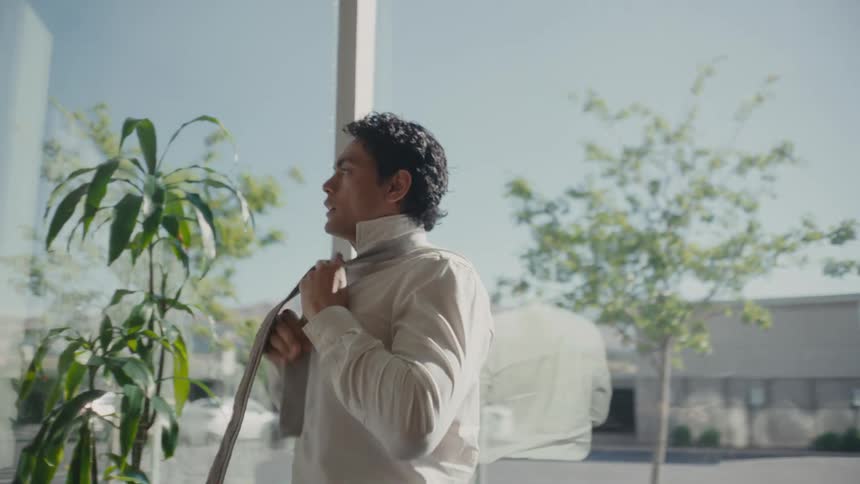 Man in an office room taking off his tie