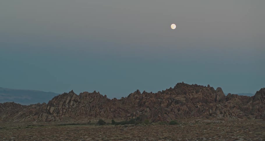 Landscape with rocky mountains and the moon on the horizon