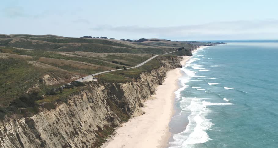 Aerial view of a long highway on the rocky seaside coast of a beach