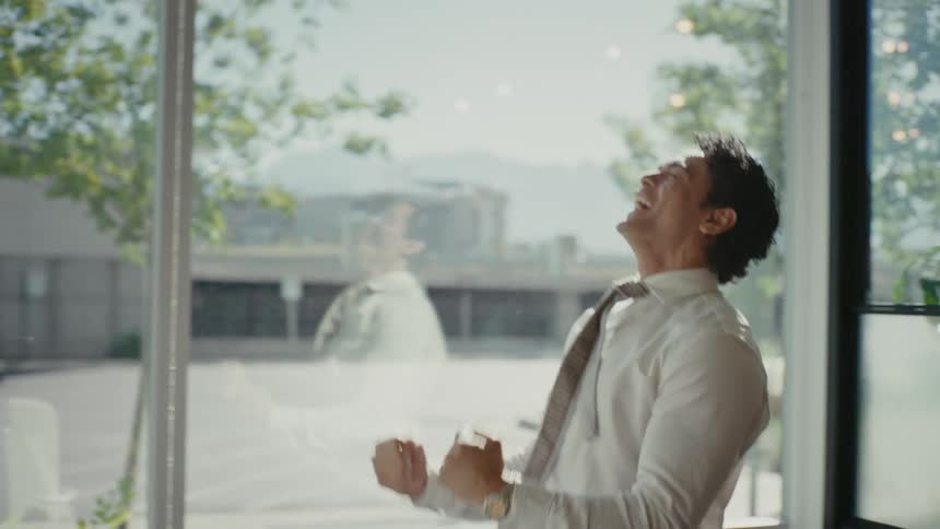 Man inside an office room jumping and vibrating with happiness