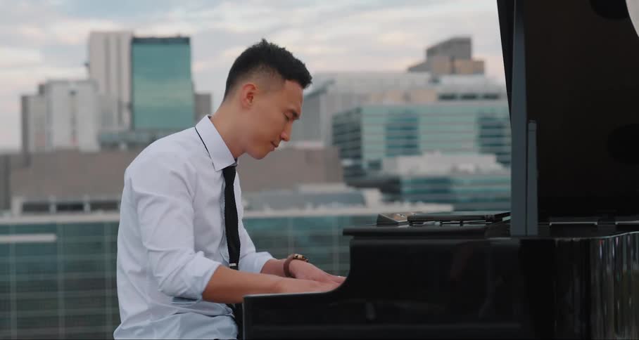 Man playing piano on the terrace of a building