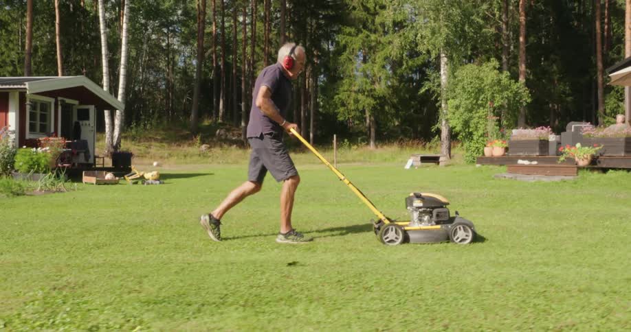 Man cutting grass in a garden