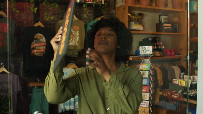 Woman inside a clothing store turning an open sign into a store window