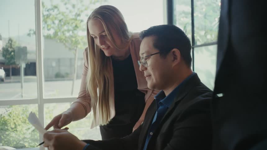 People in an office talking and discussing a document