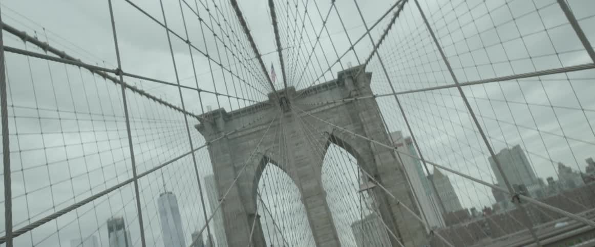 Pedestrians and a bicyclist travel across a suspension bridge