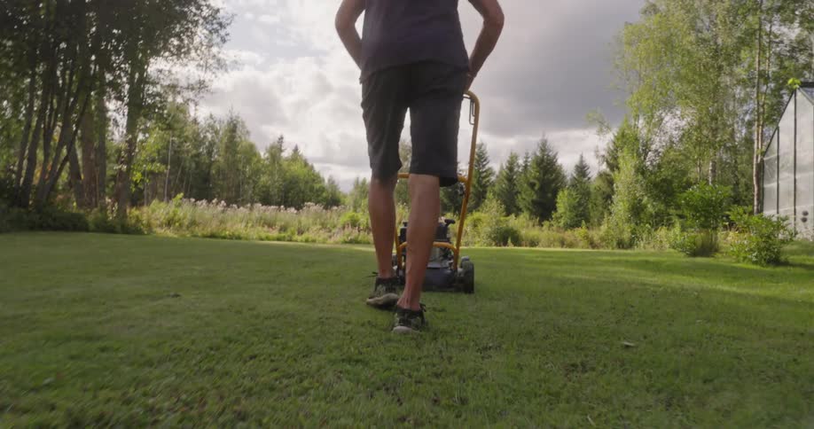 Man cutting grass in a yard