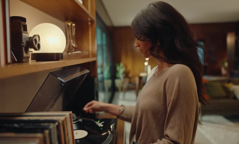 Woman putting a vinyl record to play in the living room